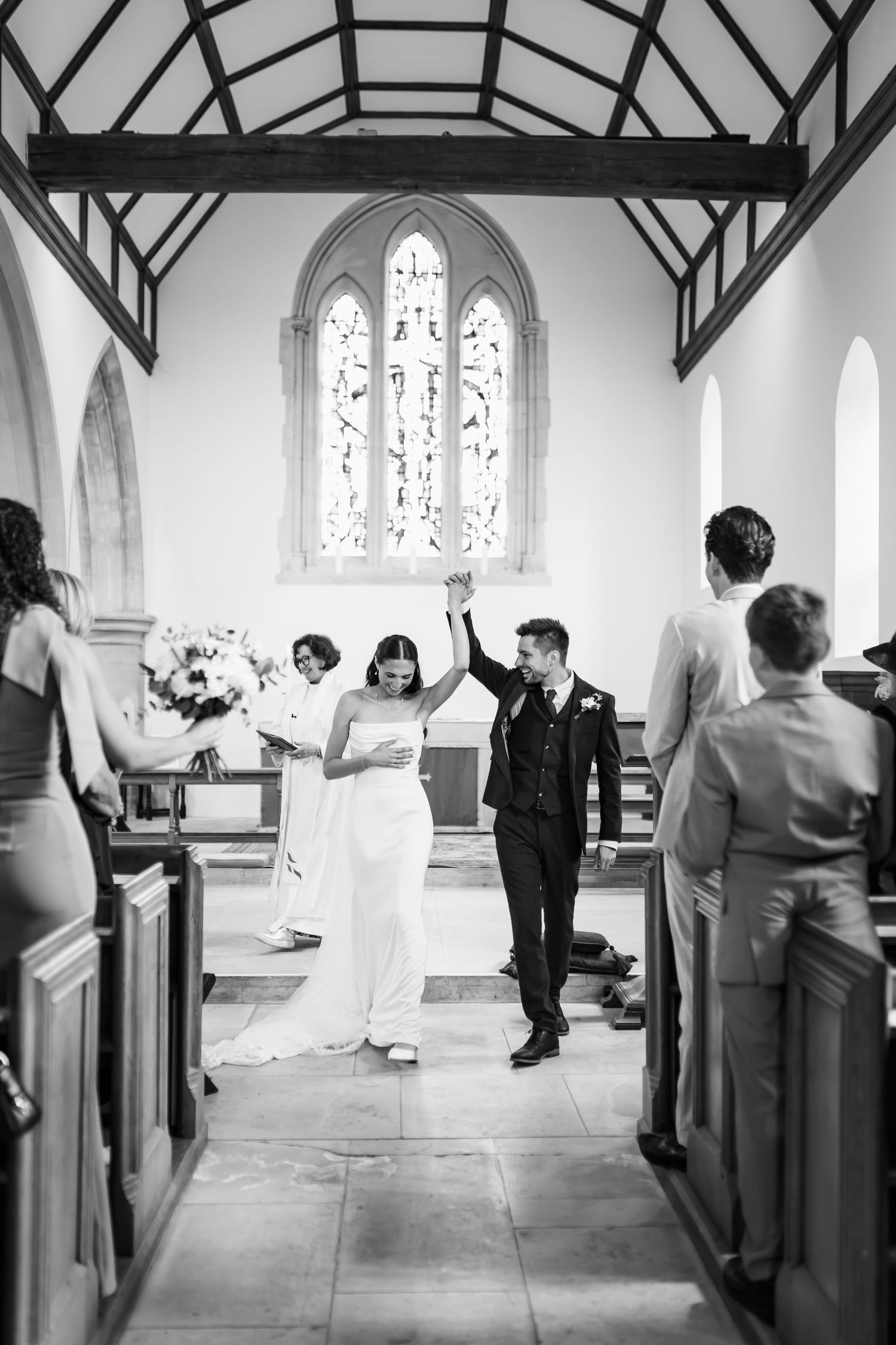 A black and white wedding photo showing an emotional first look moment in a simple indoor setting.