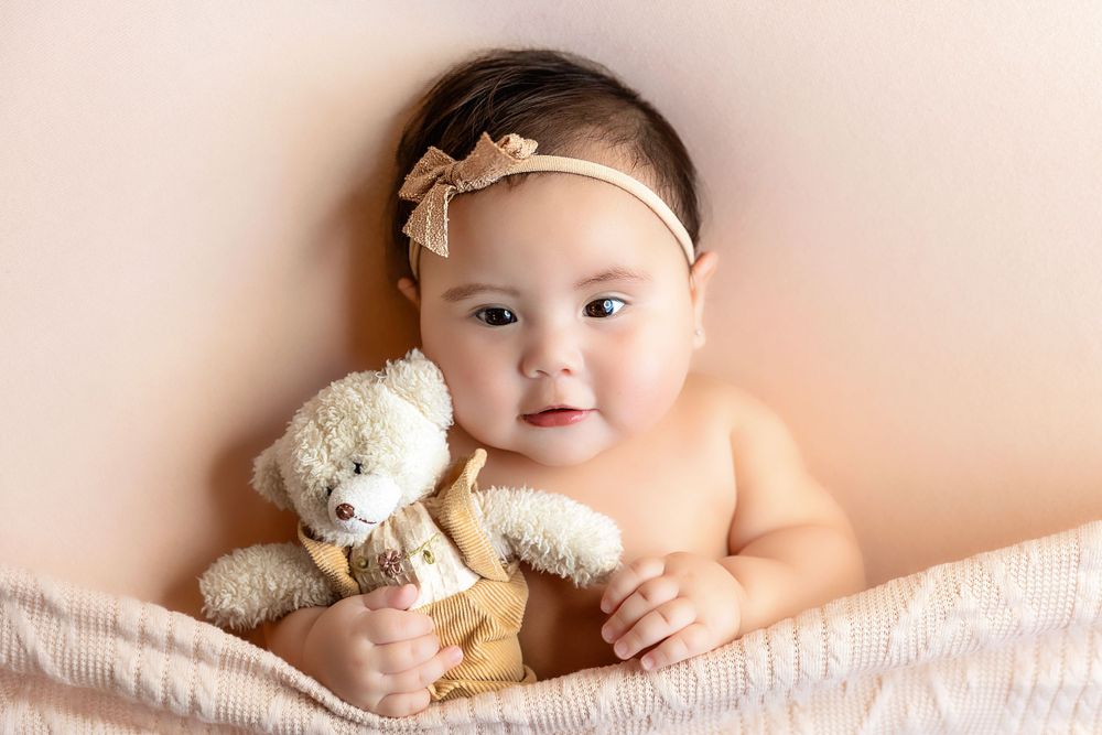 Three-month-old baby girl holding her head up during her milestone photoshoot in Fresno, showcasing early developmental