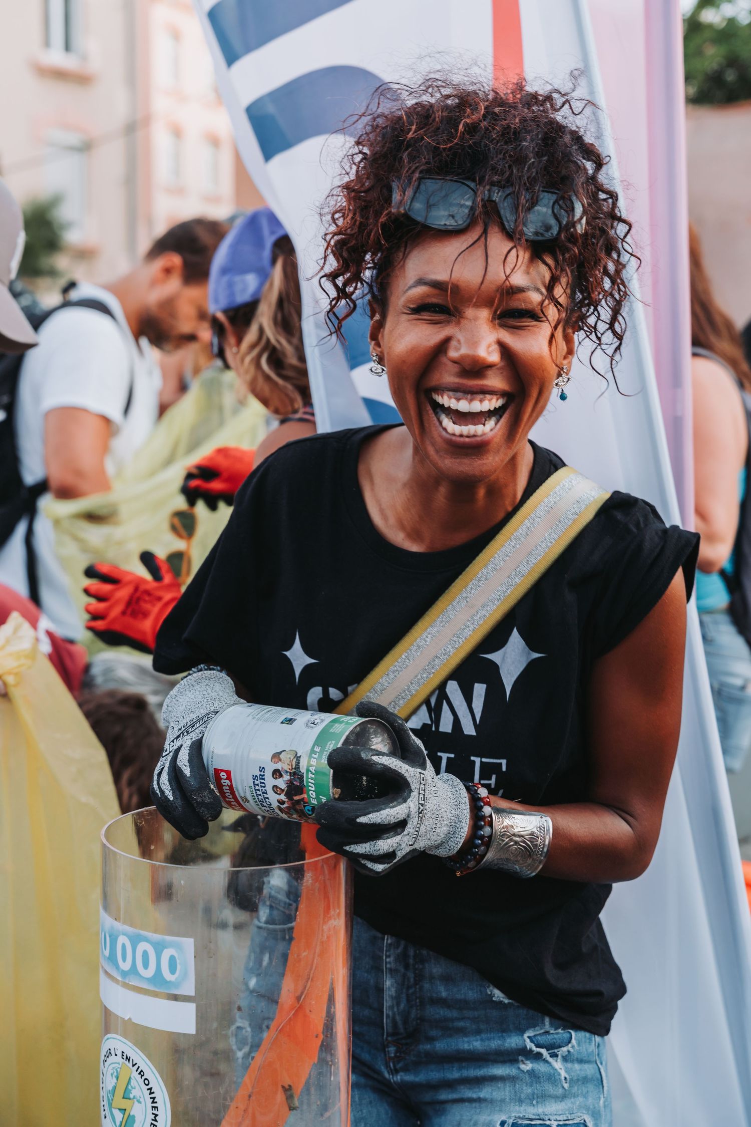 photo d'une personne souriante qui réalise un ramassage de déchet sur la plage