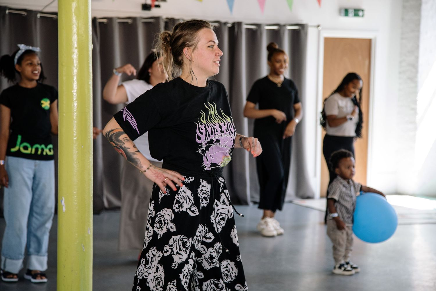 Dance or fitness class participants in studio with yellow wall and lockers.