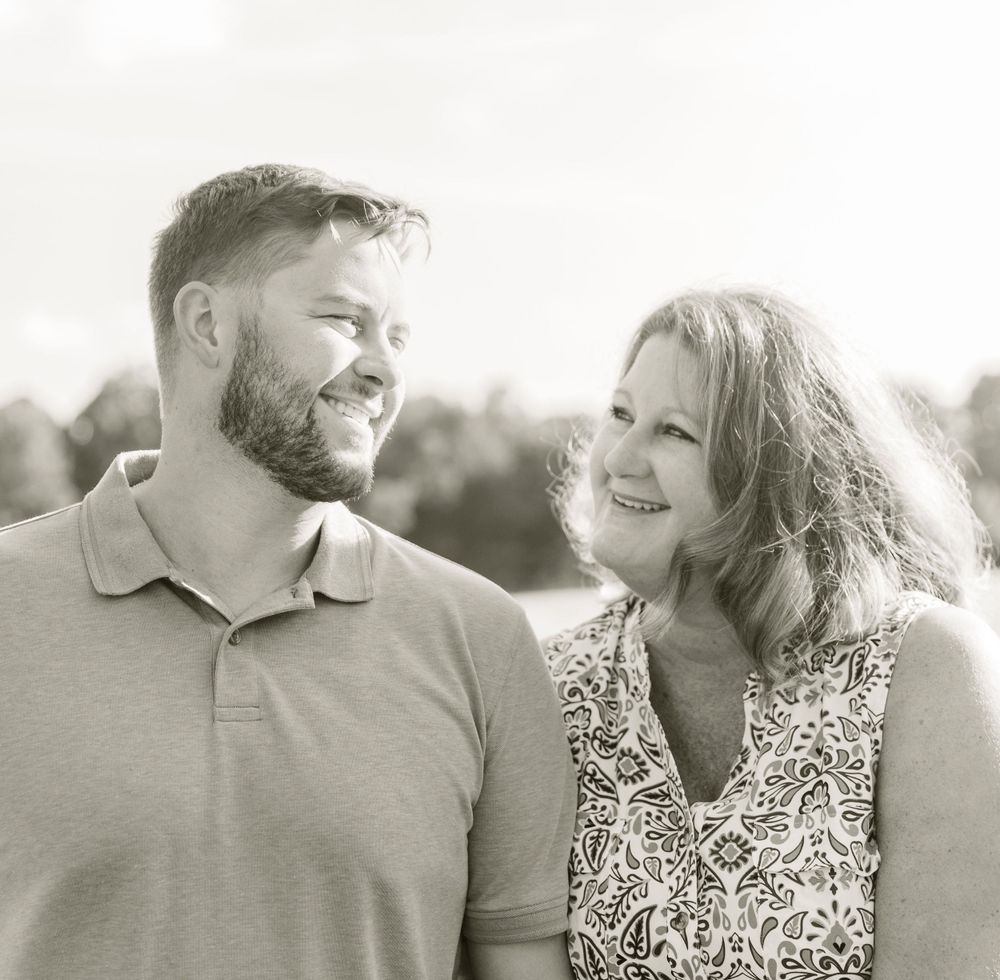 A warm black and white outdoor portrait of a couple sharing a loving moment.