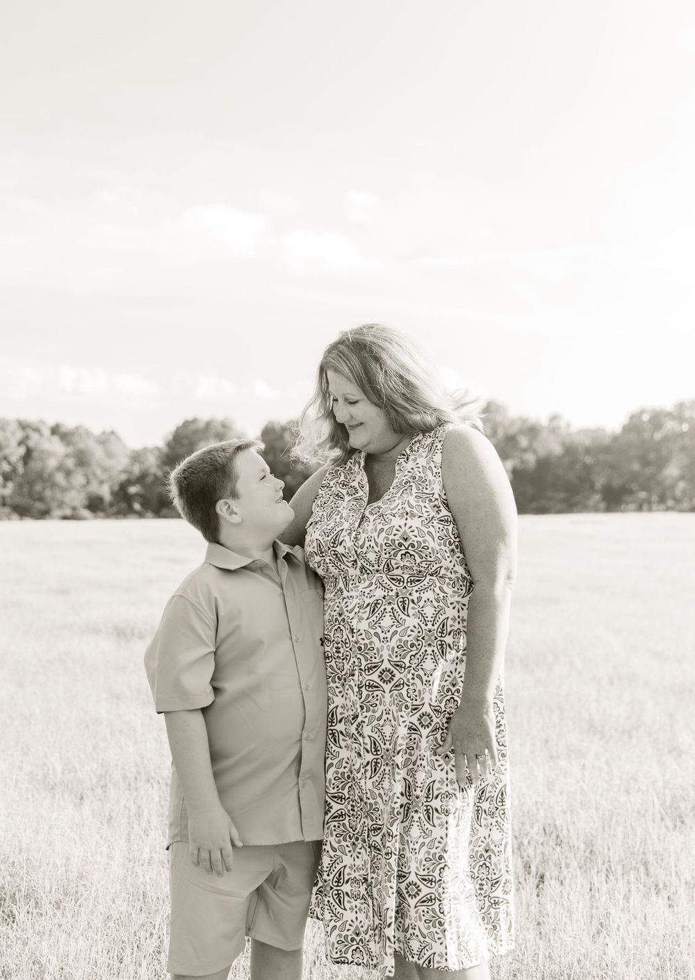 A heartwarming black and white portrait of two family members sharing a joyful moment outdoors.