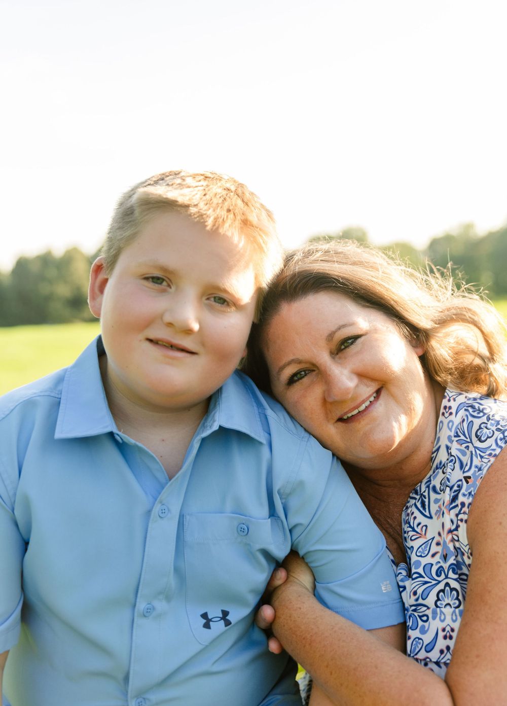 A tender portrait of two people smiling together in warm afternoon light.