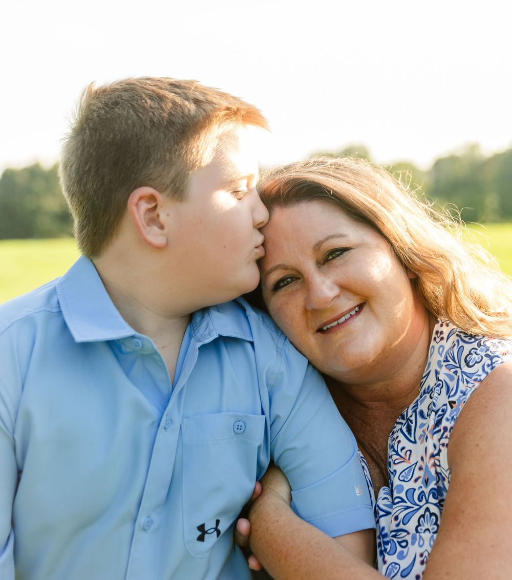 An affectionate moment captured between two people in a sunny field.