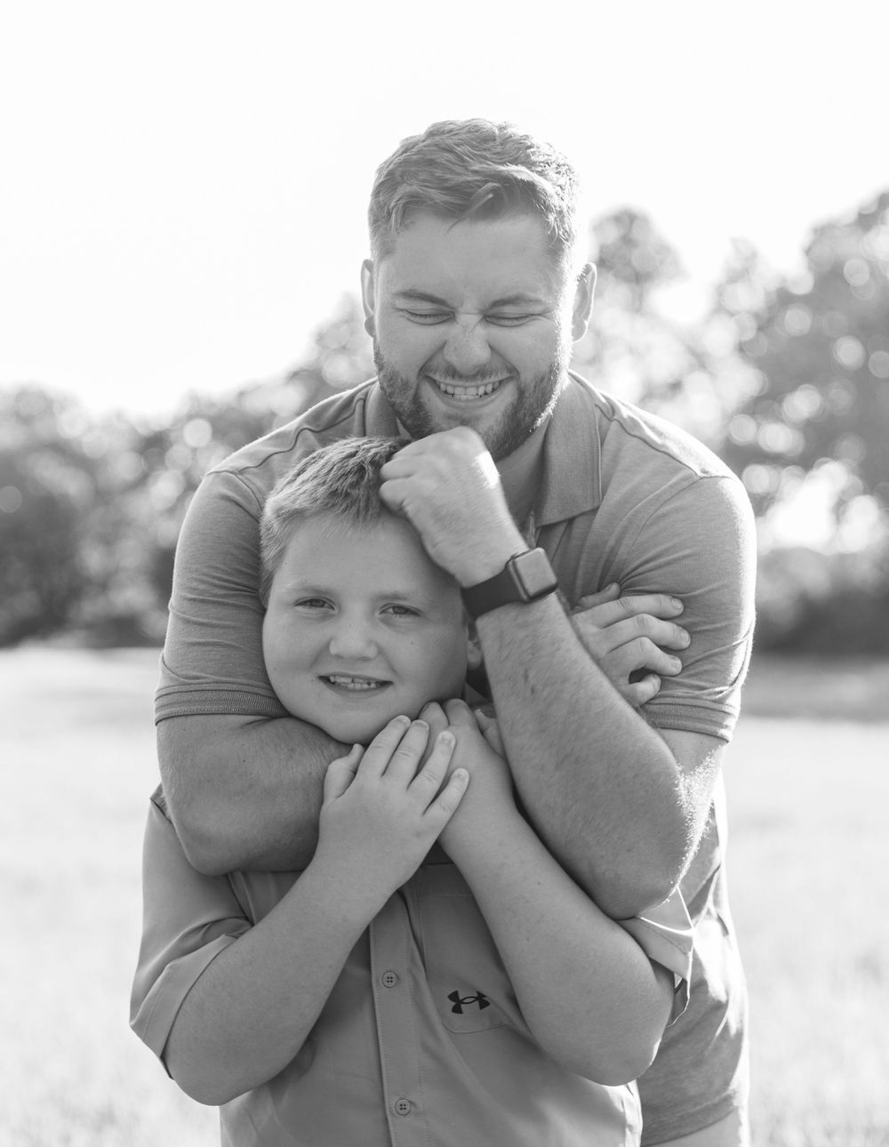 A playful black and white portrait showing a warm embrace and genuine laughter.