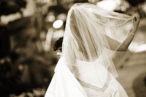 Artistic sepia photo of bride's flowing veil in natural light.