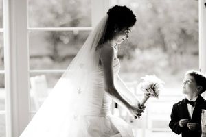 Black and white candid wedding moment with young ring bearer.