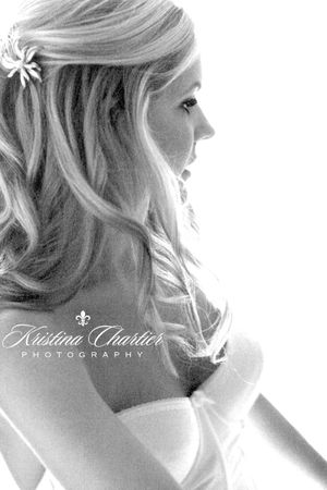 Artistic black and white side profile portrait showing soft waves in blonde hair with floral accent.