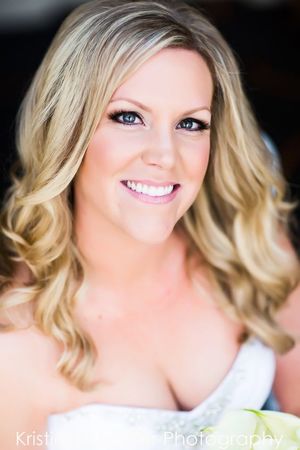 Elegant bridal portrait with soft makeup and flowing blonde curls.