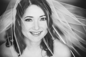 A black and white portrait of a bride wearing a flowing veil.