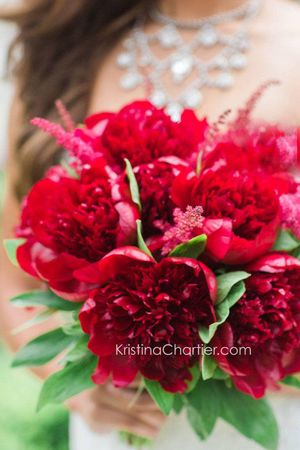 Vibrant red peony bridal bouquet with crystal necklace detail.
