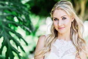 Wedding portrait with lace dress against tropical greenery background.