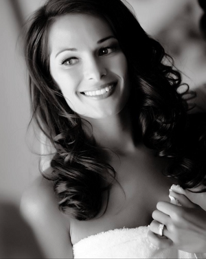 Black and white portrait showing radiant smile and flowing dark curls.