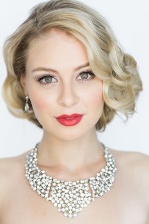 Glamorous beauty portrait with crystal statement necklace and classic red lip.
