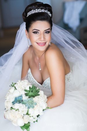 Bridal portrait showcasing crystal tiara, veil and white bouquet with succulents.
