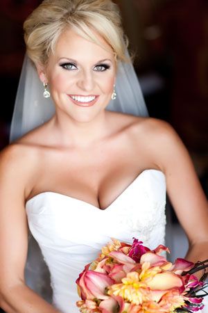 Classic bridal portrait featuring strapless wedding gown and peach-toned bouquet.