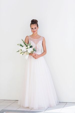 Full-length bridal portrait in flowing white tulle gown holding classic white bouquet.