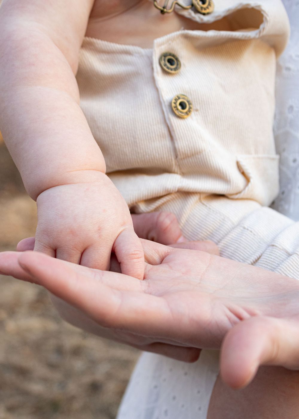 baby holding moms finger