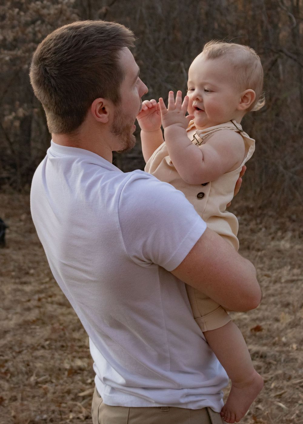 dad holding clapping baby
