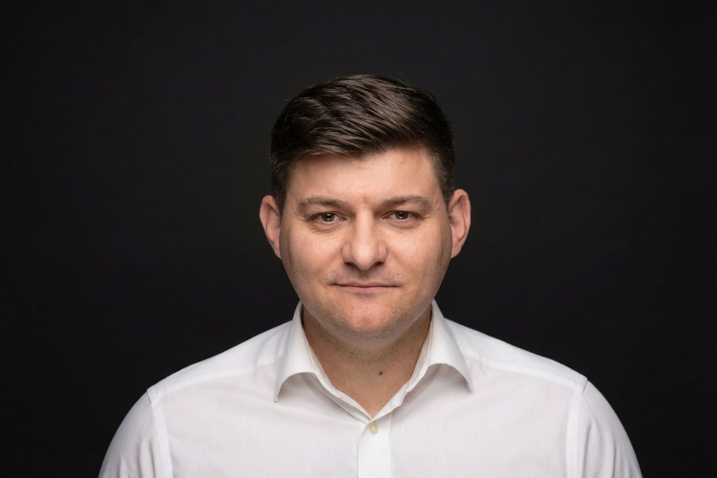 Portrait of person wearing grey sweater against blurred background with soft lighting.