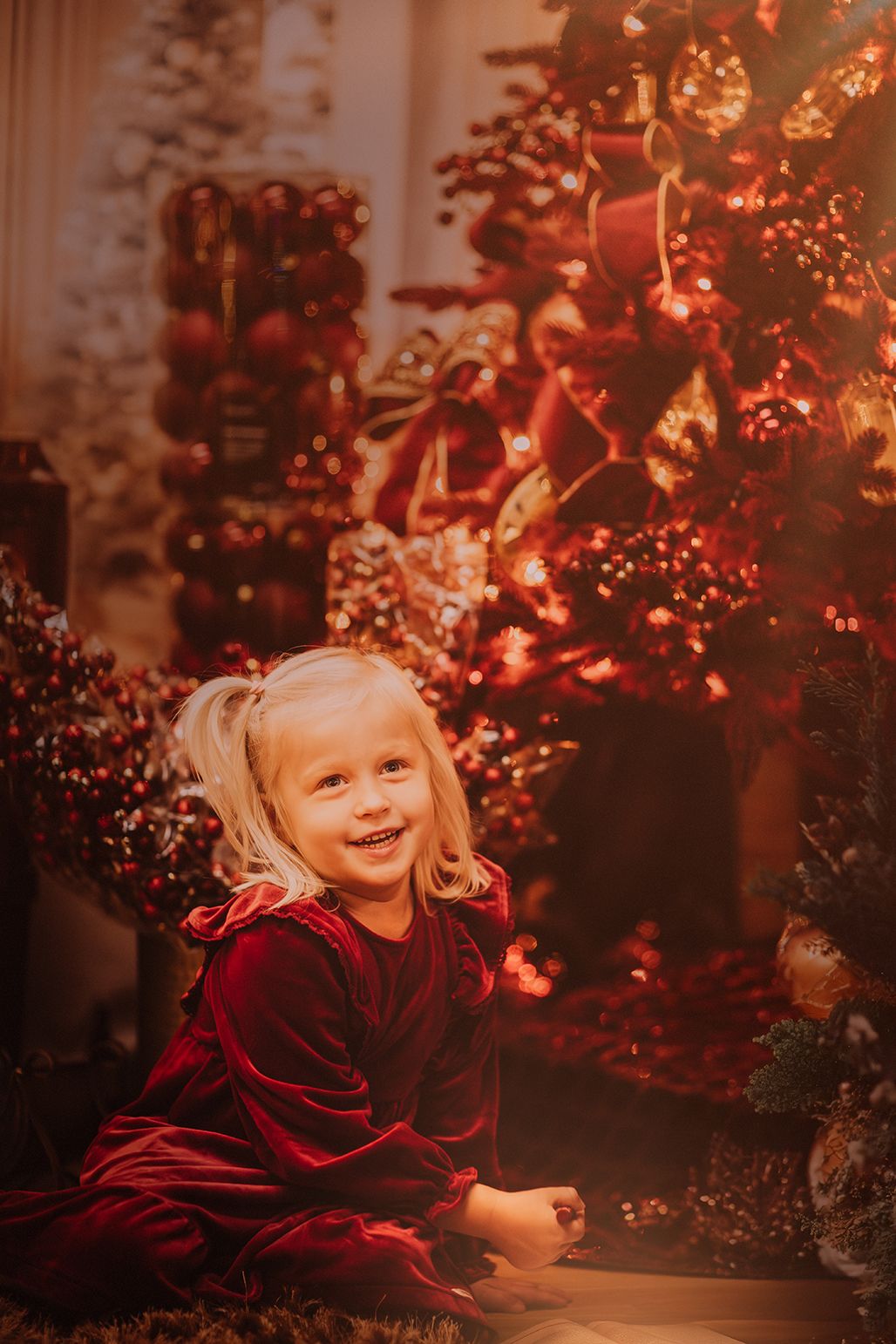 Beautifully decorated Christmas tree with pink and white ornaments glowing in warm indoor lighting.