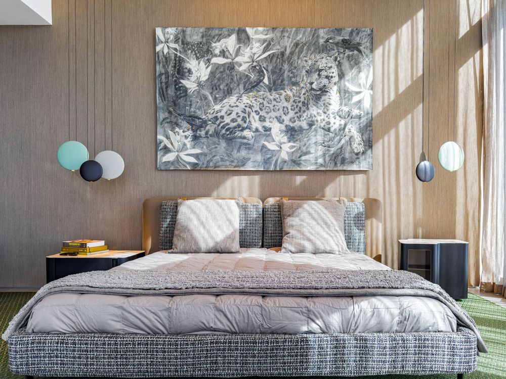 Modern bedroom featuring wooden ceiling panels, large windows, and contemporary gray bedding.