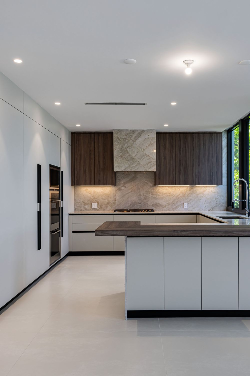 Sleek modern kitchen with white cabinetry, dark wood accents, and clean minimalist design.