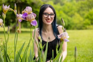 Garden portrait setting with blooming purple iris flowers in background.