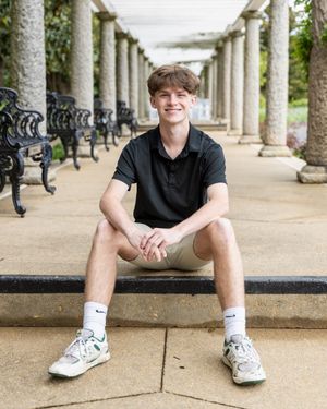 Casual portrait session along stone colonnade with benches.