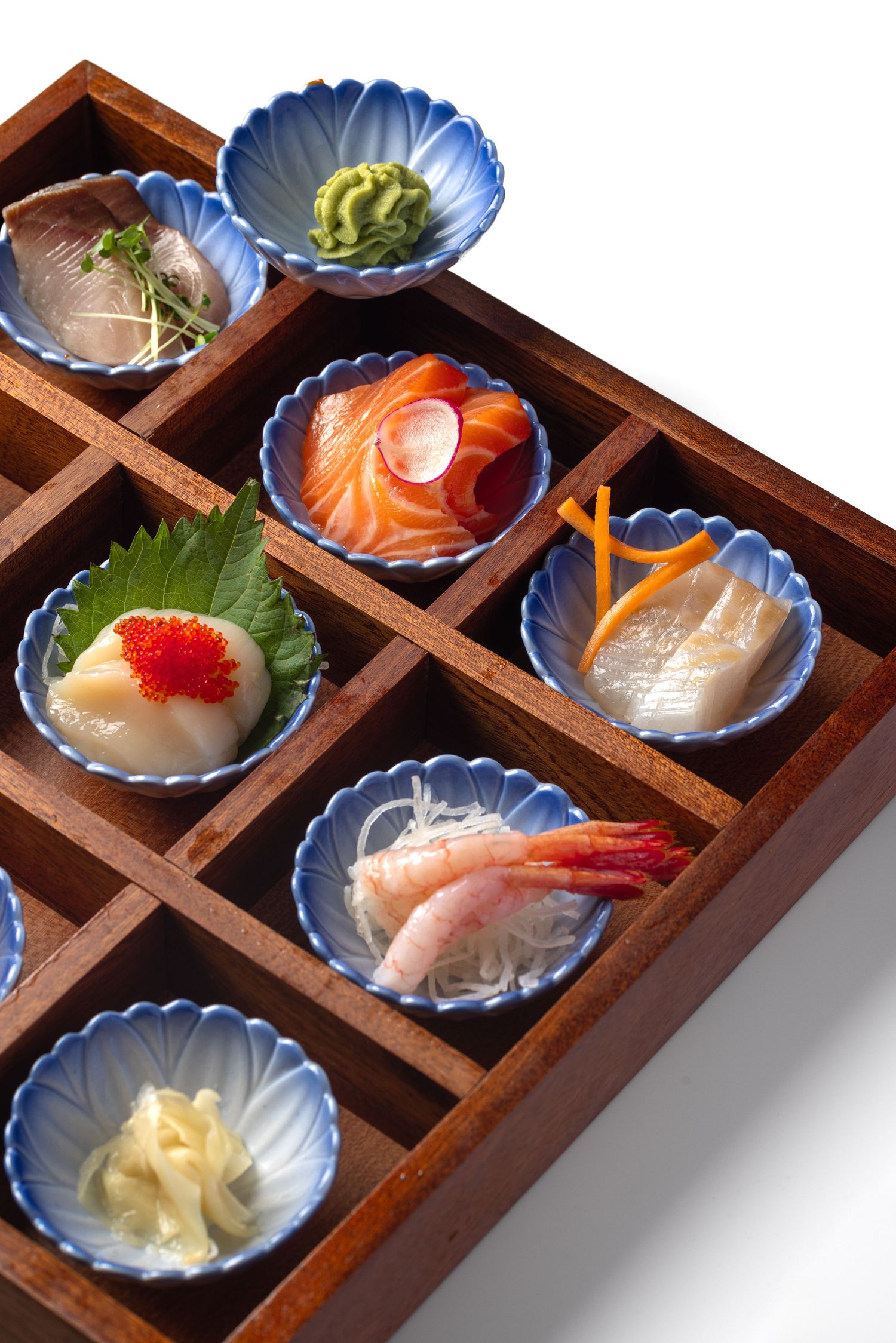 Japanese sashimi bento box with salmon, prawns and wasabi in blue ceramic dishes at Roppongi restaurant, food product photography