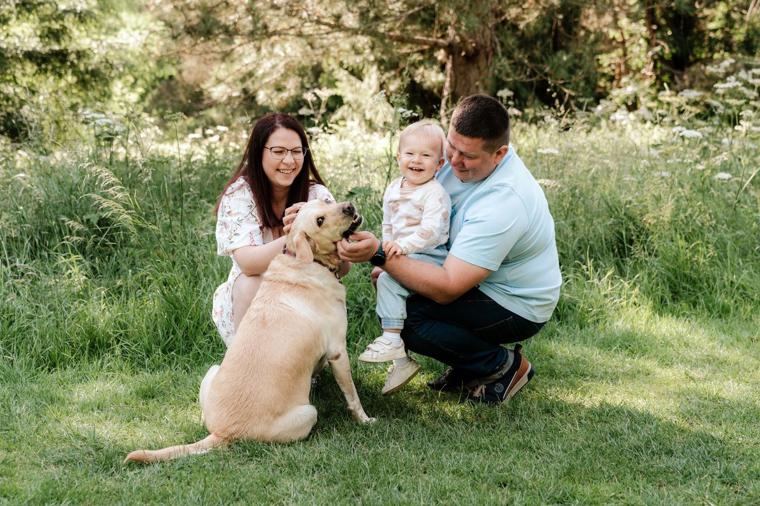Family enjoying springtime in woodland with blooming bluebells.