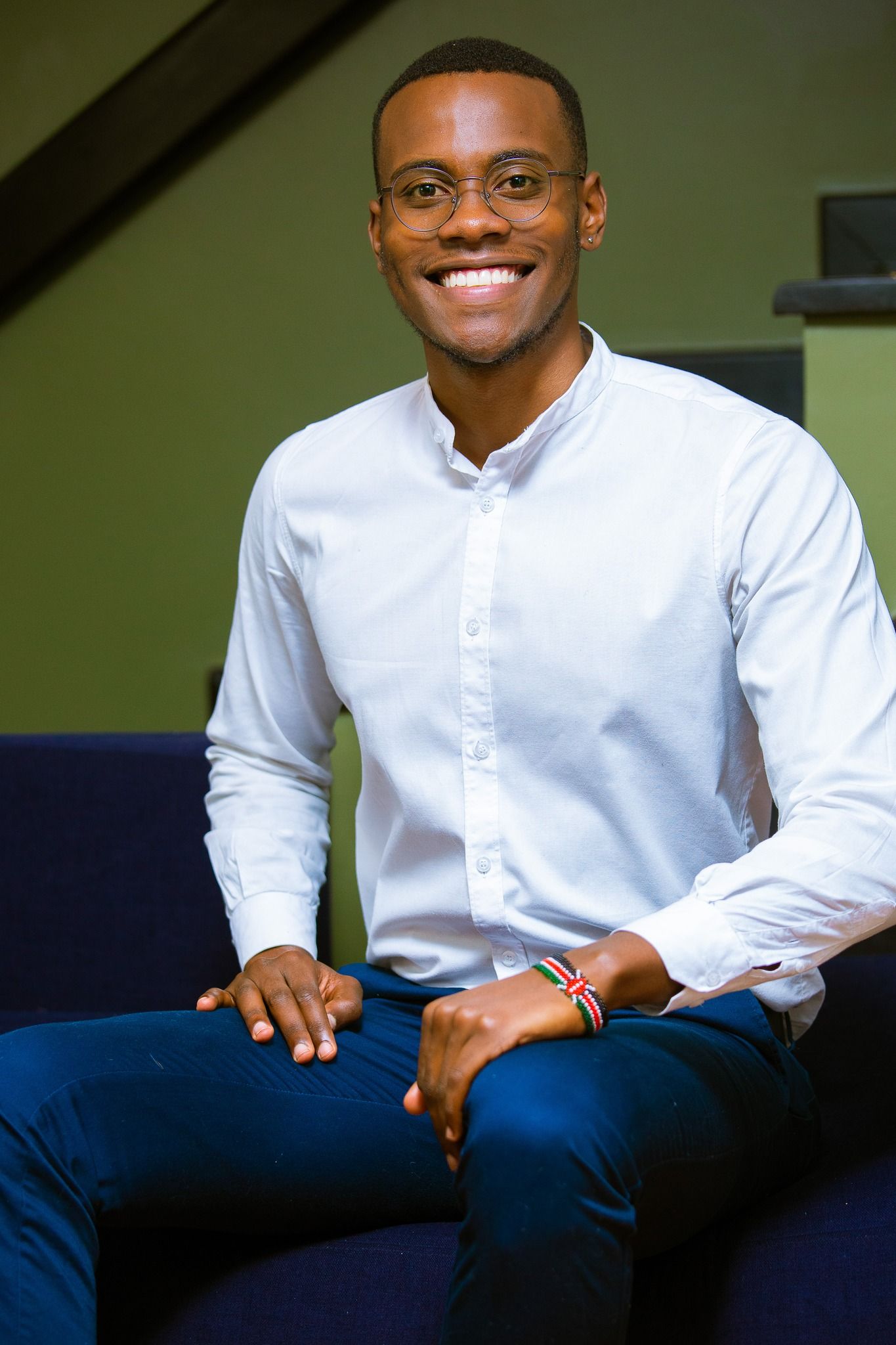 Professional wearing a white button-down shirt and navy pants in a casual office setting in Nairobi Kenya