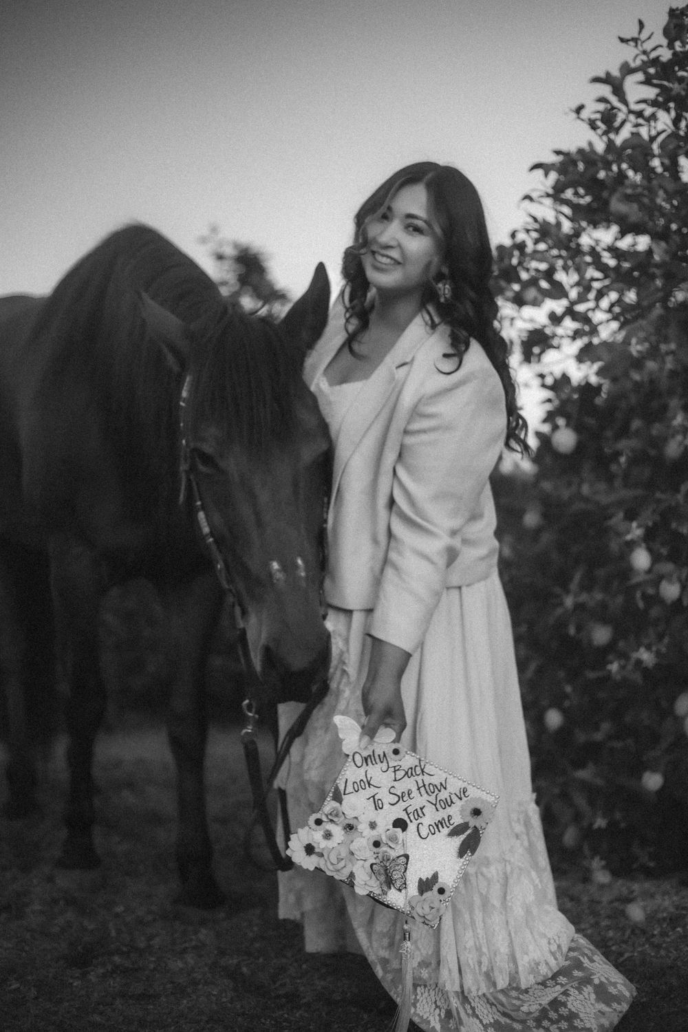 Veterinarian graduate posing with horse and her cap to celebrate accomplishment in SoCal