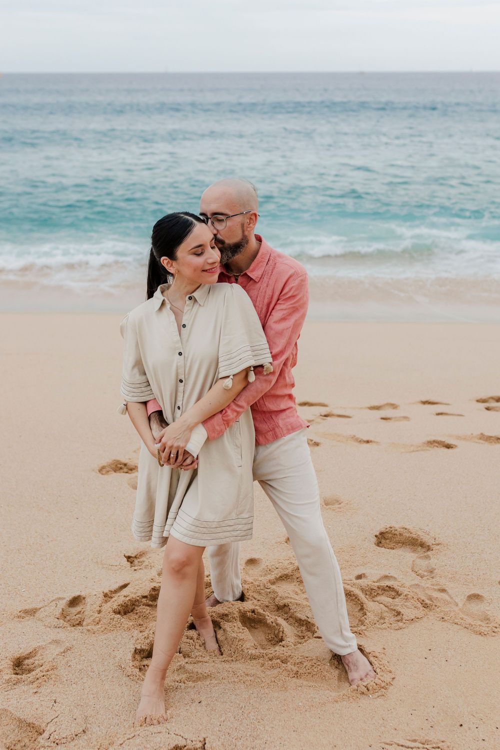 Newlyweds walking hand in hand on Cabo beach