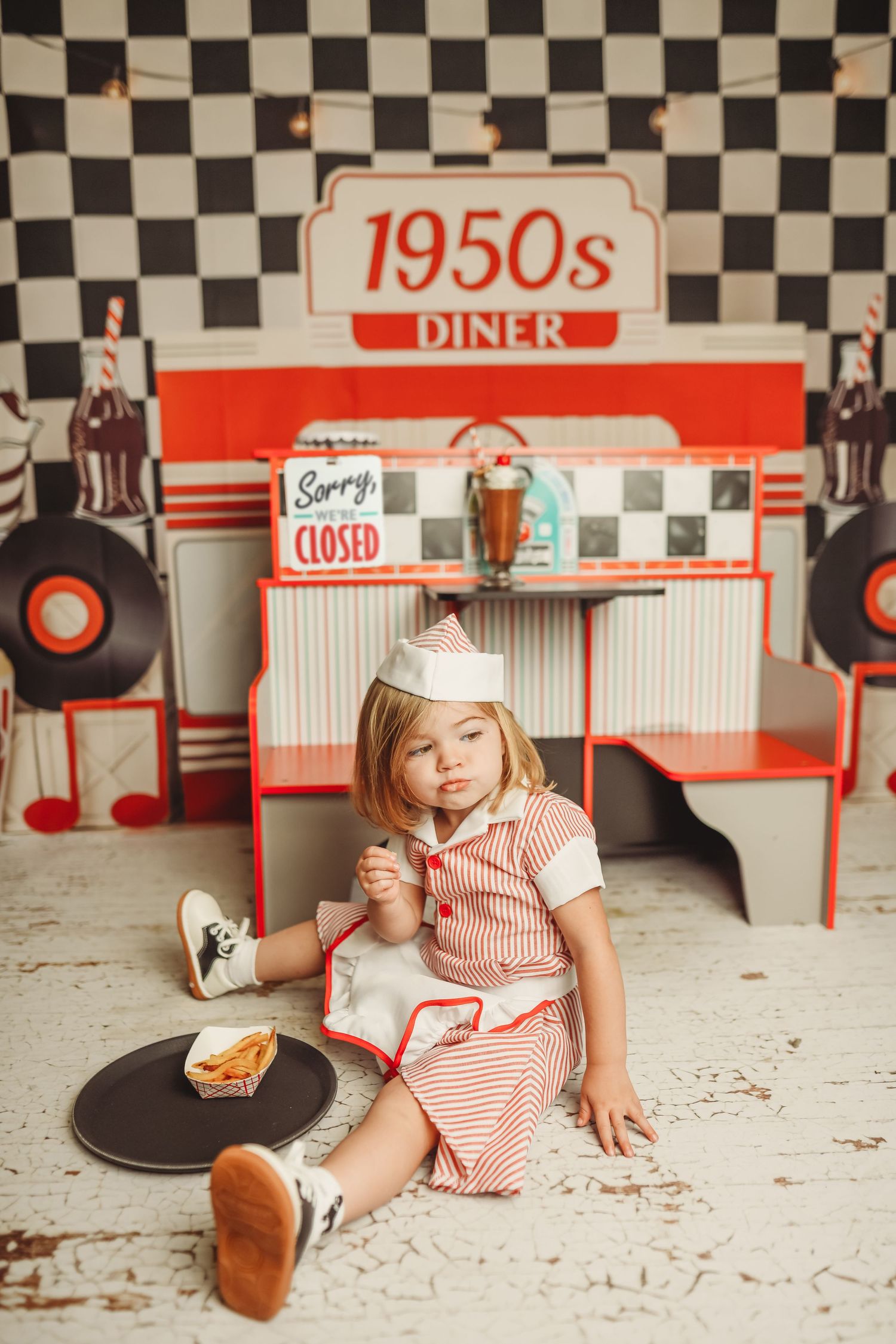 Retro diner setting with black and white checkered walls and 1950s decor.