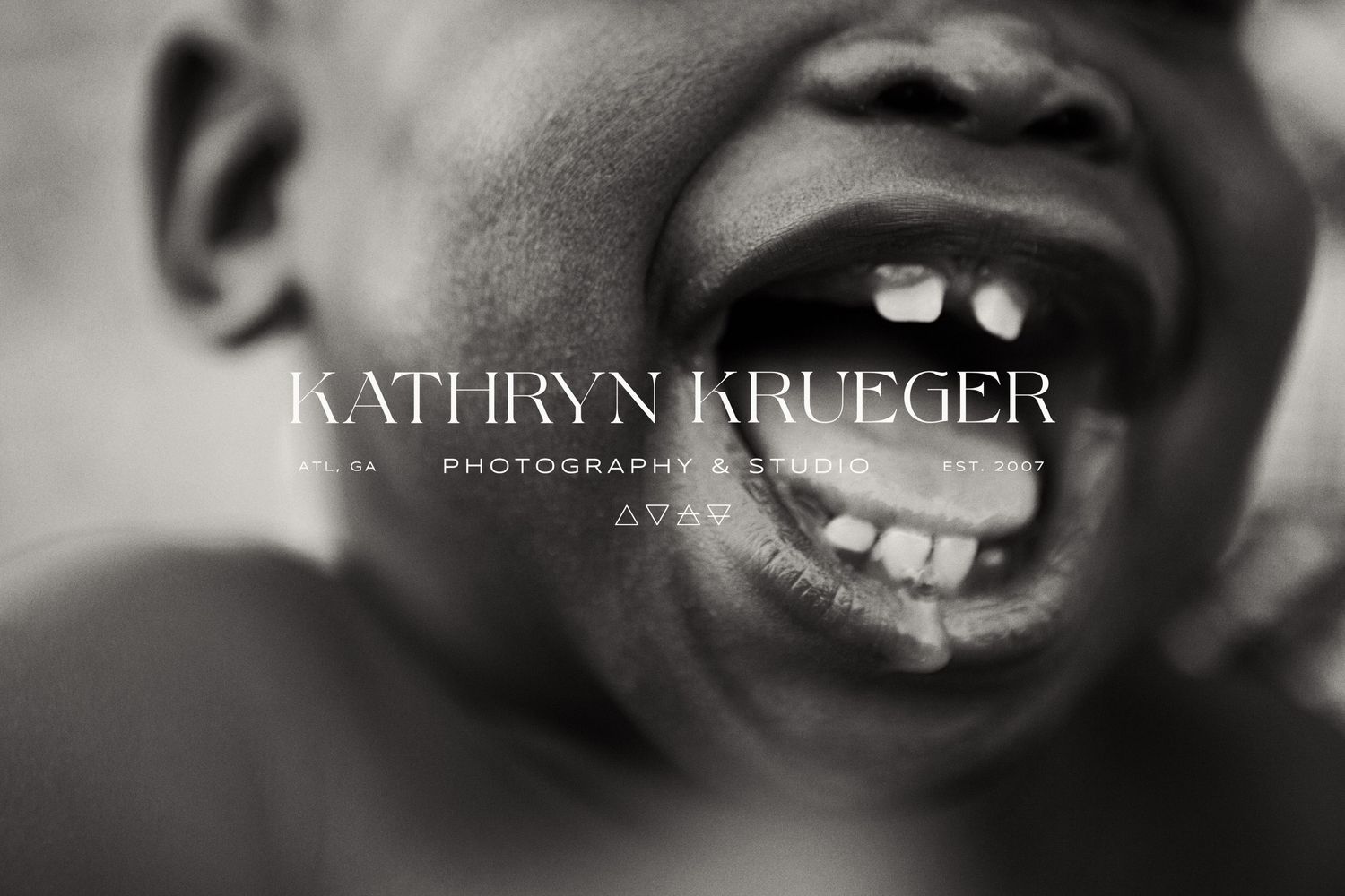 Close-up black and white photo of bright joyful smile with gap teeth.