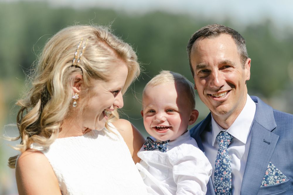 A candid moment of laughter shared during a sunny outdoor wedding celebration.