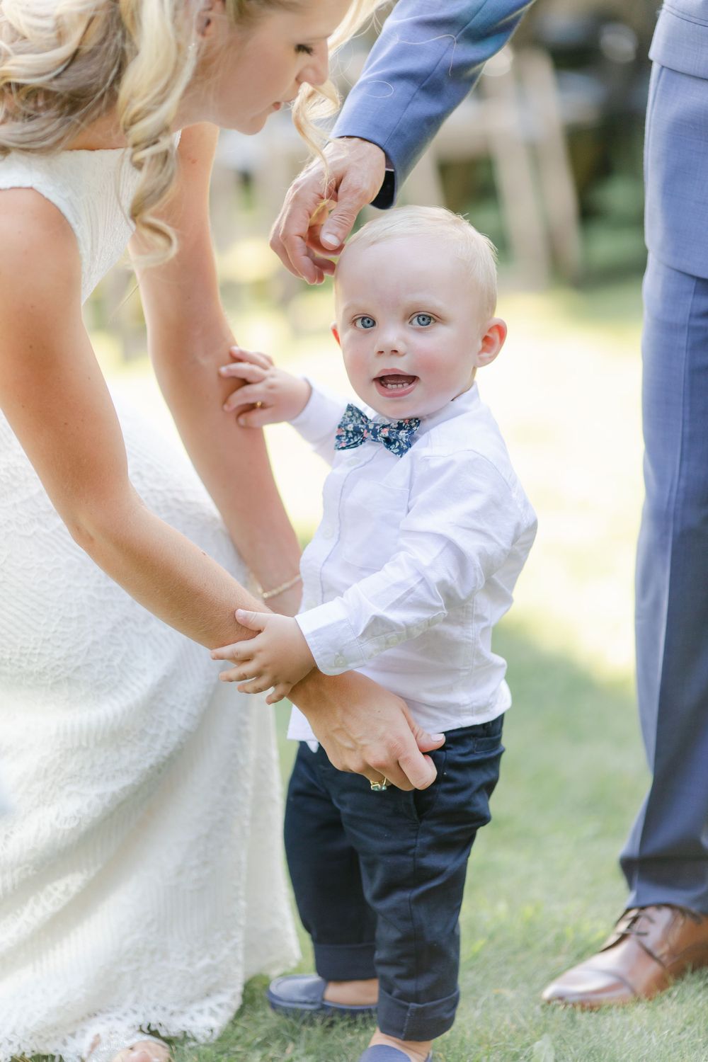 An intimate family moment captured during a wedding celebration outdoors.