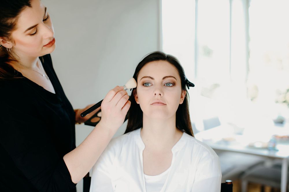 make up artist applying blush to clients face