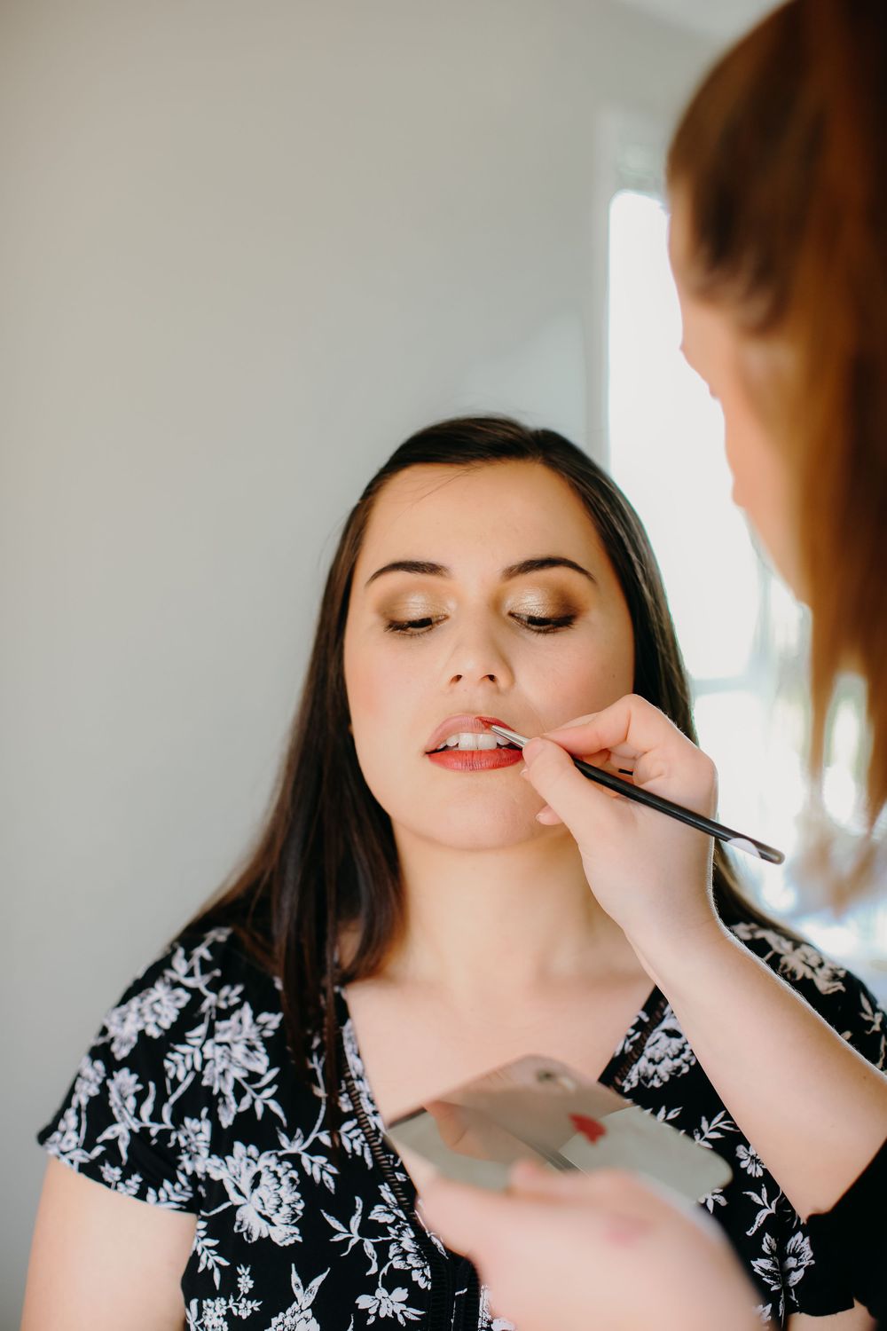 makeup artist professional branding shoot with model applying lipstick