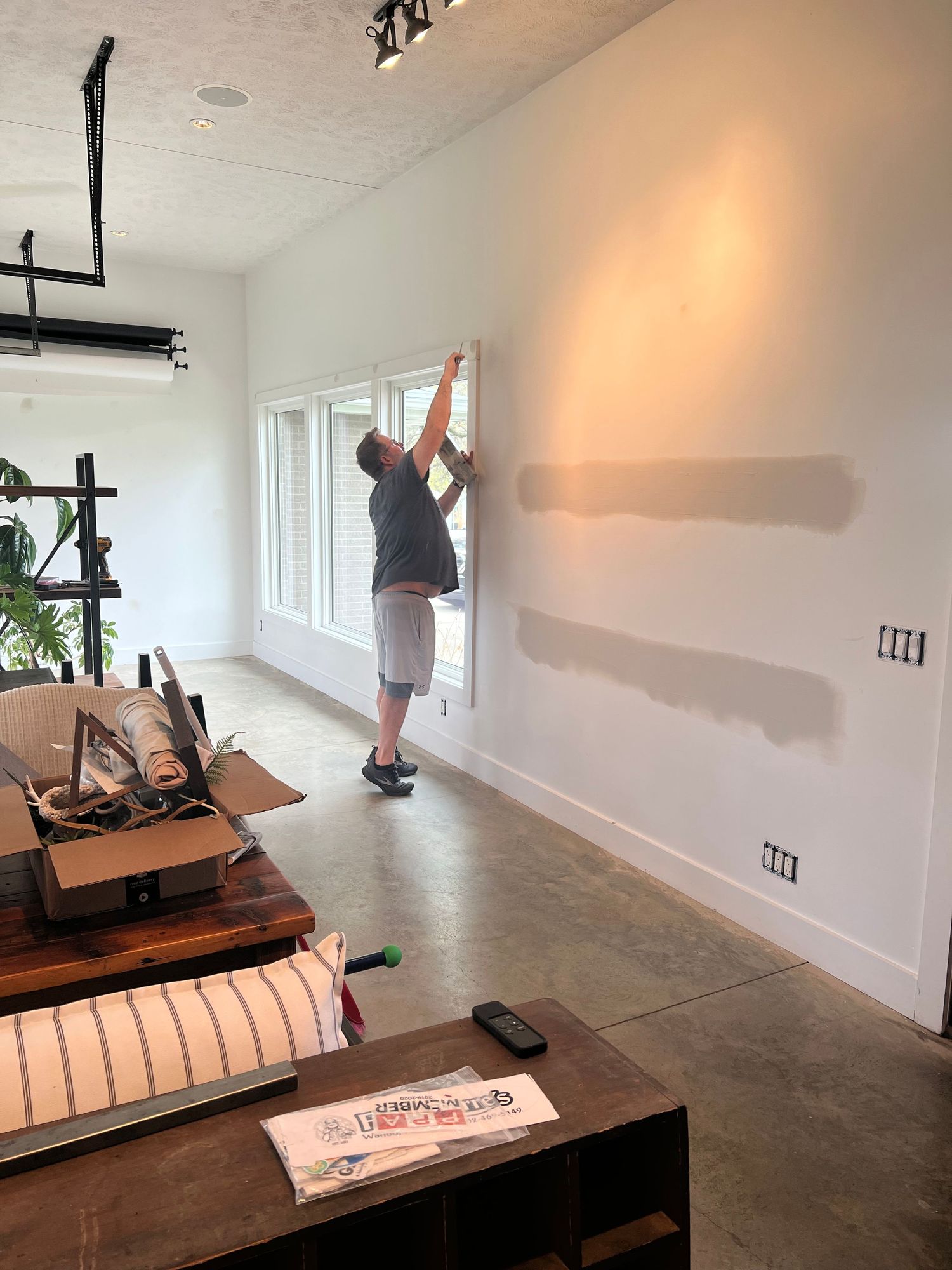 Home renovation in progress showing installation work near windows and furniture.