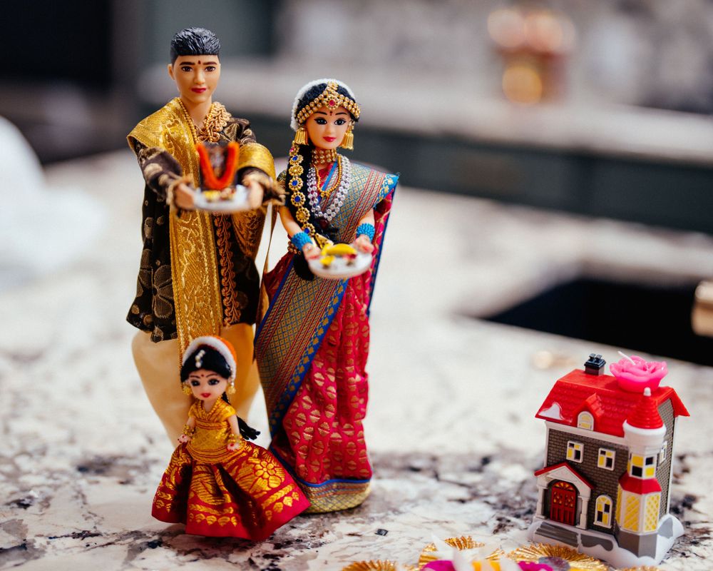 Decorative Indian family figurines with traditional clothing and a small house ornament.