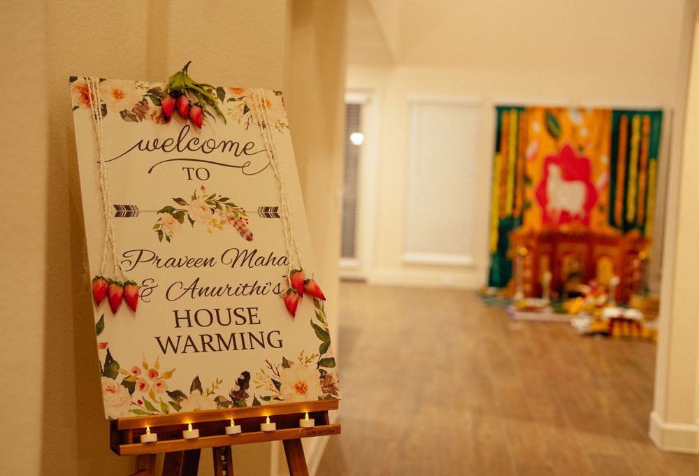 Welcome sign for Indian house warming ceremony with decorative floral elements.
