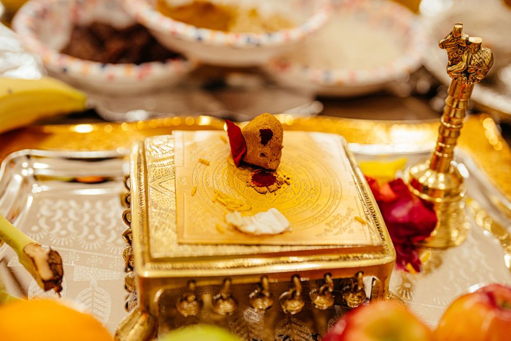 Close-up of ornate golden box surrounded by fruits and decorative items on a festive table.