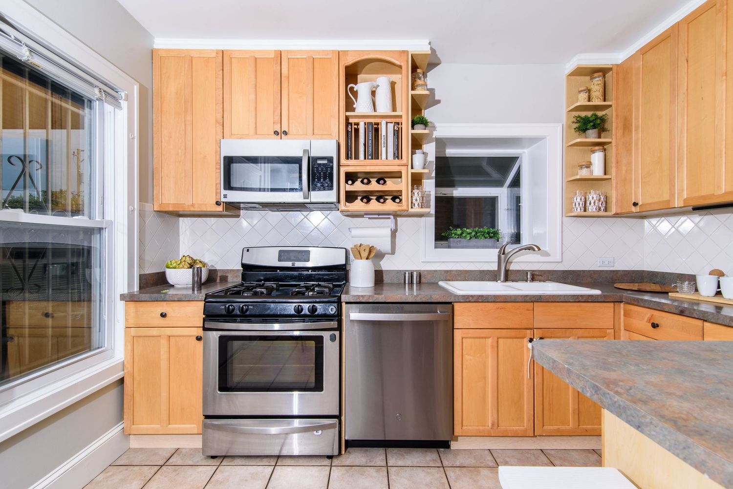 Contemporary kitchen with light wood cabinets, stainless appliances, and granite countertops.