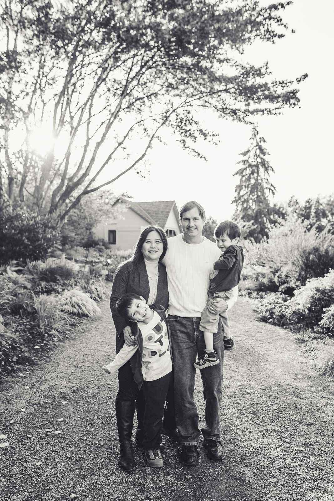 Black and white image of family smiling for the camera in a garden