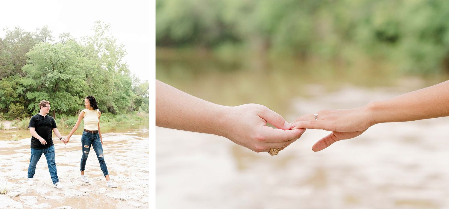 Two people holding hands together near a river with lush green trees in the background.