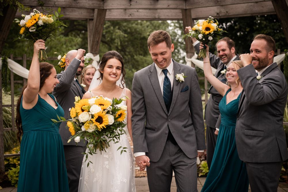 Bride and groom candid walking with wedding party cheering at Stratford Country Club wedding
