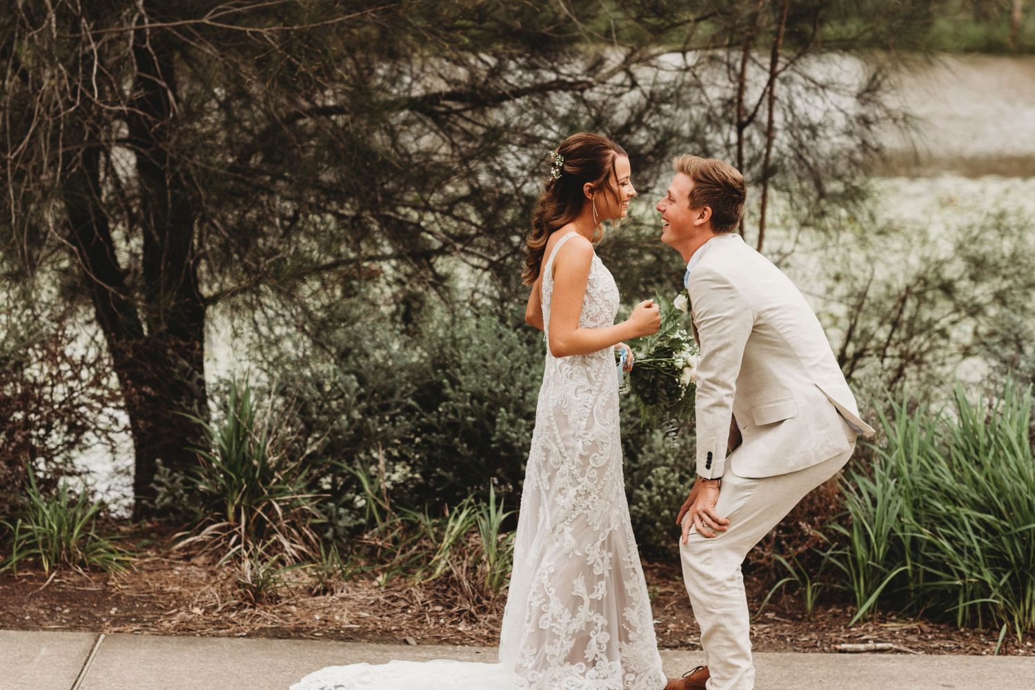 Couple sharing intimate moment on path surrounded by greenery.