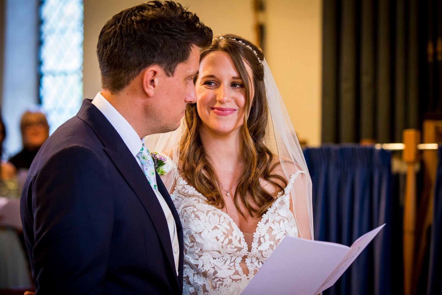 Couple shares intimate moment during indoor wedding ceremony.